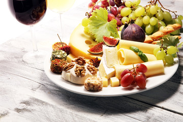 Cheese platter with different cheese and grapes.