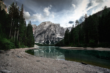 Pragser Wildsee in the summer from a long distance with clouds and dark colors