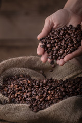 Crop close-up view of sack of fresh coffee beans with hands - 224439339