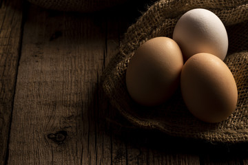 Fresh chicken eggs in farm lying on linen cloth on wooden table