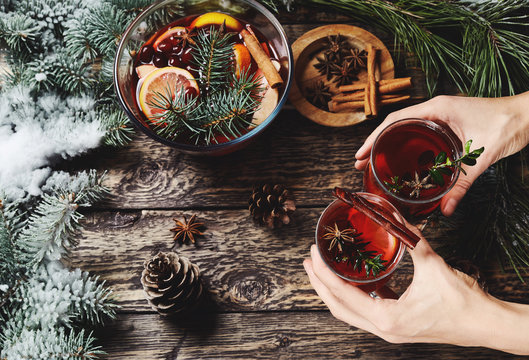 hands holding glasses with mulled wine for Christmas and festive period