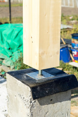 Adjustable wooden post support. Construction of a wooden house.