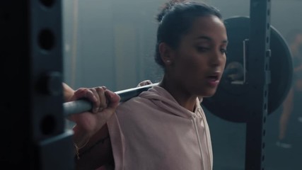 fitness woman athlete training using barbell doing squats enjoying intense workout personal trainer helping friends exercise high five in gym - Powered by Adobe