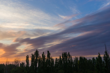 Landscape with dramatic light - beautiful golden sunset with saturated sky and clouds.