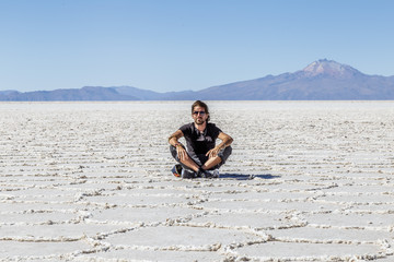 Homme assis dans le désert de sel de Uyuni en Bolivie Paysage voyage aventure