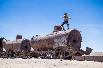Homme debout sur vieux train rouillé métal dans le désert de sel de Bolivie Cimetière