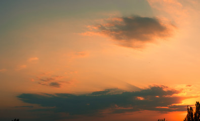 Landscape with dramatic light - beautiful golden sunset with saturated sky and clouds.