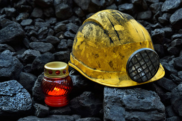 Vigil light, candle with mining helmet on cheap of coal - obrazy, fototapety, plakaty
