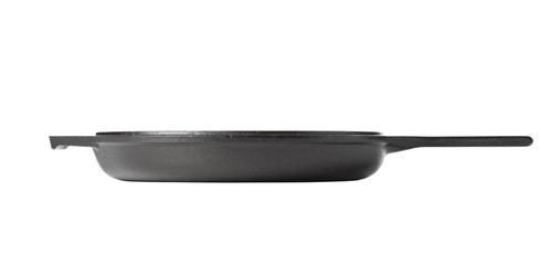 Empty, clean black cast iron pan or dutch oven side view over white
