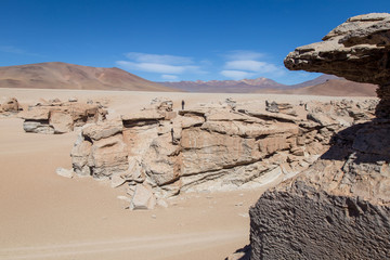 Fototapeta na wymiar Femme silhouette en haut d'un rocher dans le désert de sel de Bolivie 