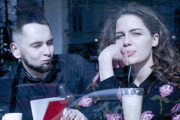 Love, tenderness and relationship concept. Young happy couple having fun in cafe.