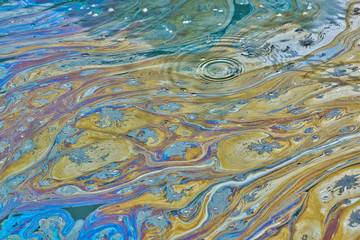 Oil pollution on water surface environmental damage concept in Texas waterway, colorful sheen...