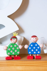 There is a couple of dolls on the shelter made by wood. They are smiling and looks very happy. The...