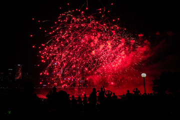 Beautiful red fireworks with people background at night