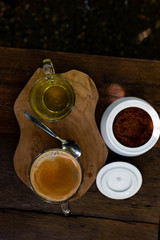 Coffee and tea are on the wooden table in green garden
