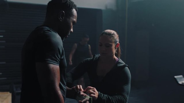 fitness man training pull ups exercise enjoying intense fitness workout personal trainer helping diverse friends in gym