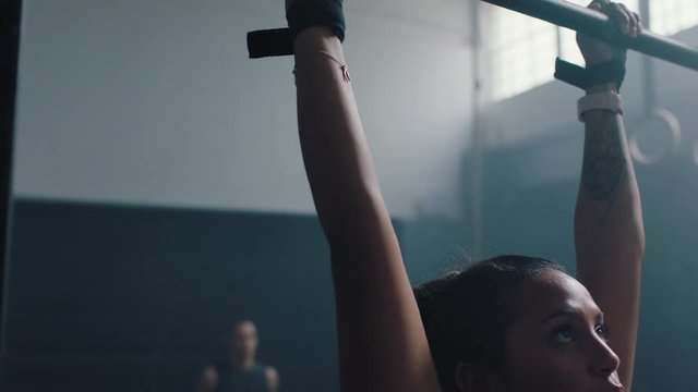 fitness woman training pull ups exercise enjoying intense fitness workout personal trainer helping friends in gym