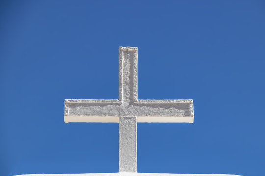 White adobe cross against a very blue sky - closeup