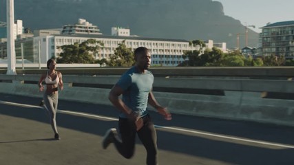 strong muscular man athlete running overtaking runners in competitive race competition on sprinting on urban city road at sunrise