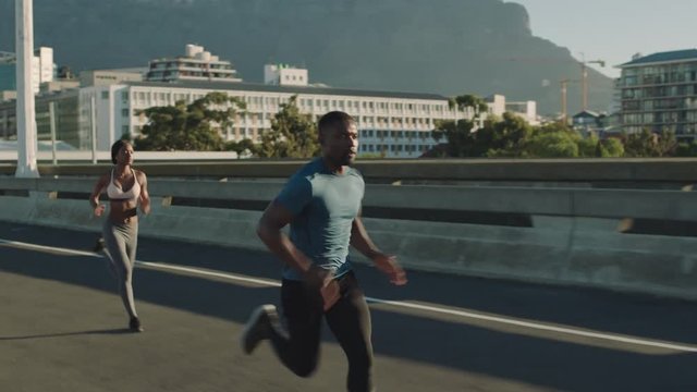 strong muscular man athlete running overtaking runners in competitive race competition on sprinting on urban city road at sunrise