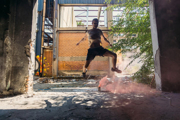 Parkour man exercising around colored smoke bomb