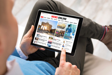 Man reading daily news online on tablet
