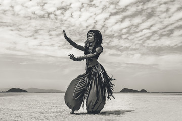Beautiful young stylish tribal dancer. Woman in oriental costume dancing outdoors