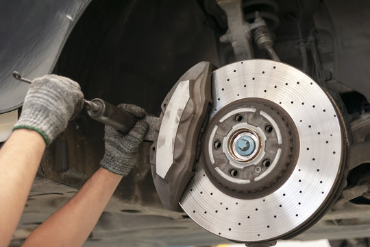  Mechanic repairing a car with replace brake disc and pads