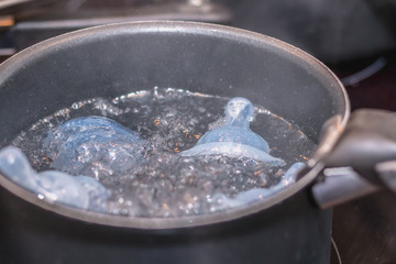 pacifier sterilization for babies in a saucepan of boiling water