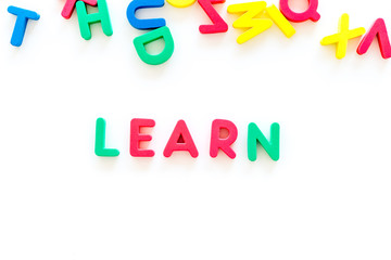 Children learn read concept. Word learn written by plastic letters on white background top view copy space