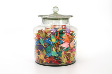 many colorful paper origami birds in the cleared glass jar