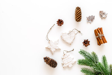 Spruce branch, cones and vintage toys in shape of spruce and stars on white background for decoration on chrismas or new year top view copy space