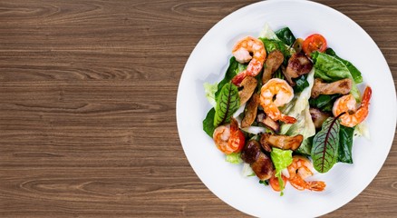 Green salad with shrimps on background