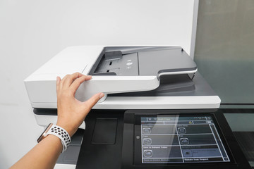 close up businesswoman use multi function printer to scan documents in office