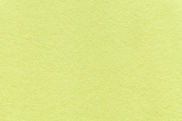 Texture of old light green paper background, closeup. Structure of dense olive cardboard