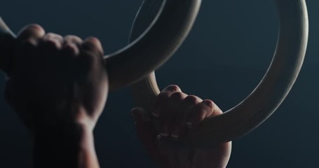 fitness woman training gymnastics exercise using rings enjoying intense muscle workout lifting weight sportswoman bodybuilding olympics practice in gym close up hands slow motion