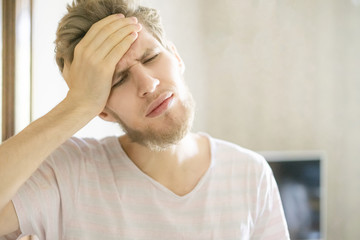 close up portrait of young bearded person suffering from strong headache f