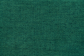 Dark green background of dense woven bagging fabric, closeup. Structure of the textile macro.