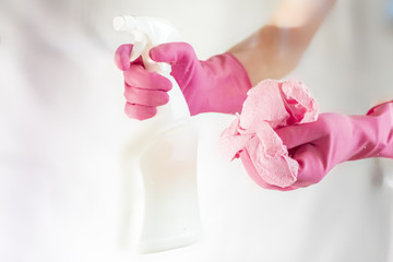 through the glass view of hand in pink glove cleaning window with sponge and spray cleaning f