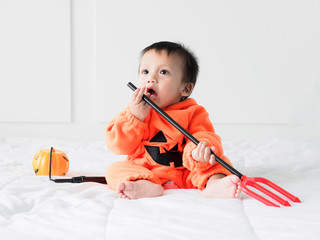 Cute baby boy dressed in pumpkin costume