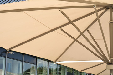 large parasol beside building with glass facade