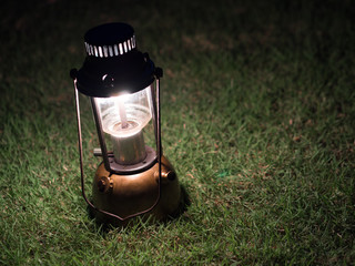 Ancient lamps illuminated with oil on the grass at night.