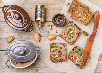 Fototapeta na wymiar Fresh homemade chicken (duck, goose, rabbit, Turkey) liver pate with almonds, pink pepper and green onions on whole grain bread with seeds. Traditional healthy snack for gourmets