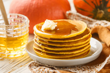 Fresh homemade pumpkin pancake with honey and butter in a white plate. Tasty Traditional healthy Breakfast for gourmets