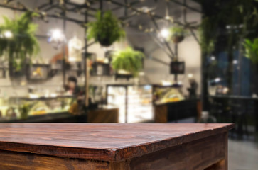 Selected focus empty brown wooden table and Coffee shop or restaurent blur background with bokeh image. for your photomontage or product display