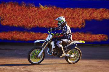 Pro motocross rider riding fmx motorbike, jumping performing extreme stunt. Professional biker jumps