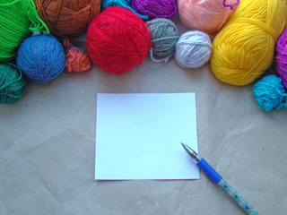A sheet of paper, a pen and a knitting yarn