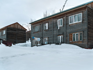 Old wooden two-storey houses drowning in the snow in winter