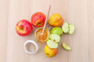 Jewish holiday Rosh Hashanah background with honey and apples on wooden table.