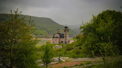 Landscape of Mavrovo national park with mountain,lake and new St Nikola church, FYR Macedonia